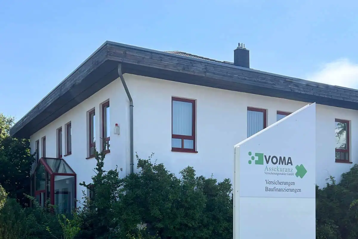 Moderne Bürogebäude der VOMA Assekuranz mit Firmenschild, Versicherungen und Baufinanzierungen.